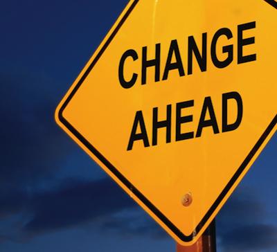 Yellow road sign reading "Change Ahead" against a deep blue dusk sky
