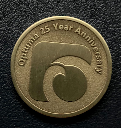 Commemorative Optuma 25-year coin showing the Optuma logo